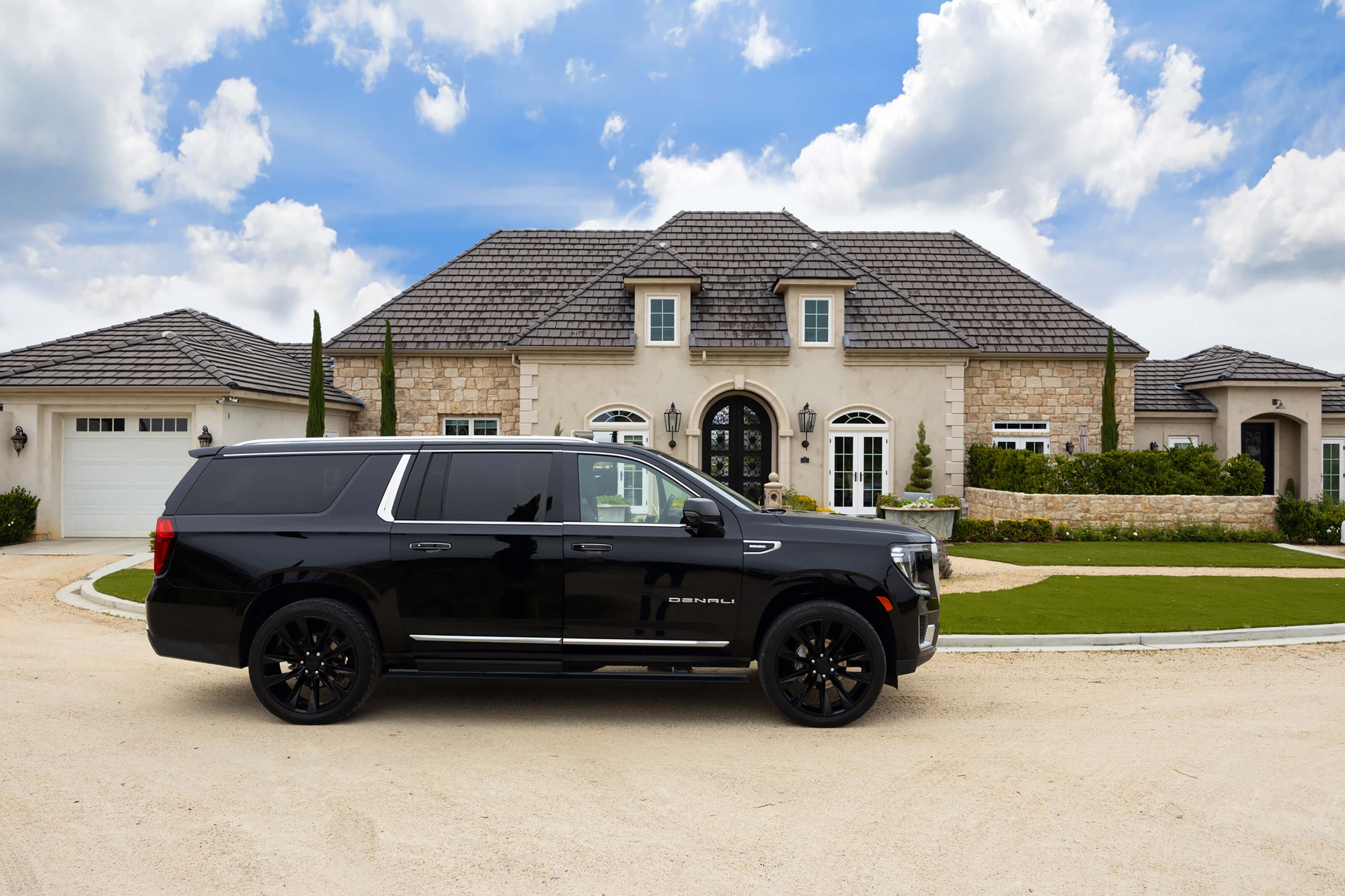 A black SUV in front of a French chateau-style bed and breakfast.