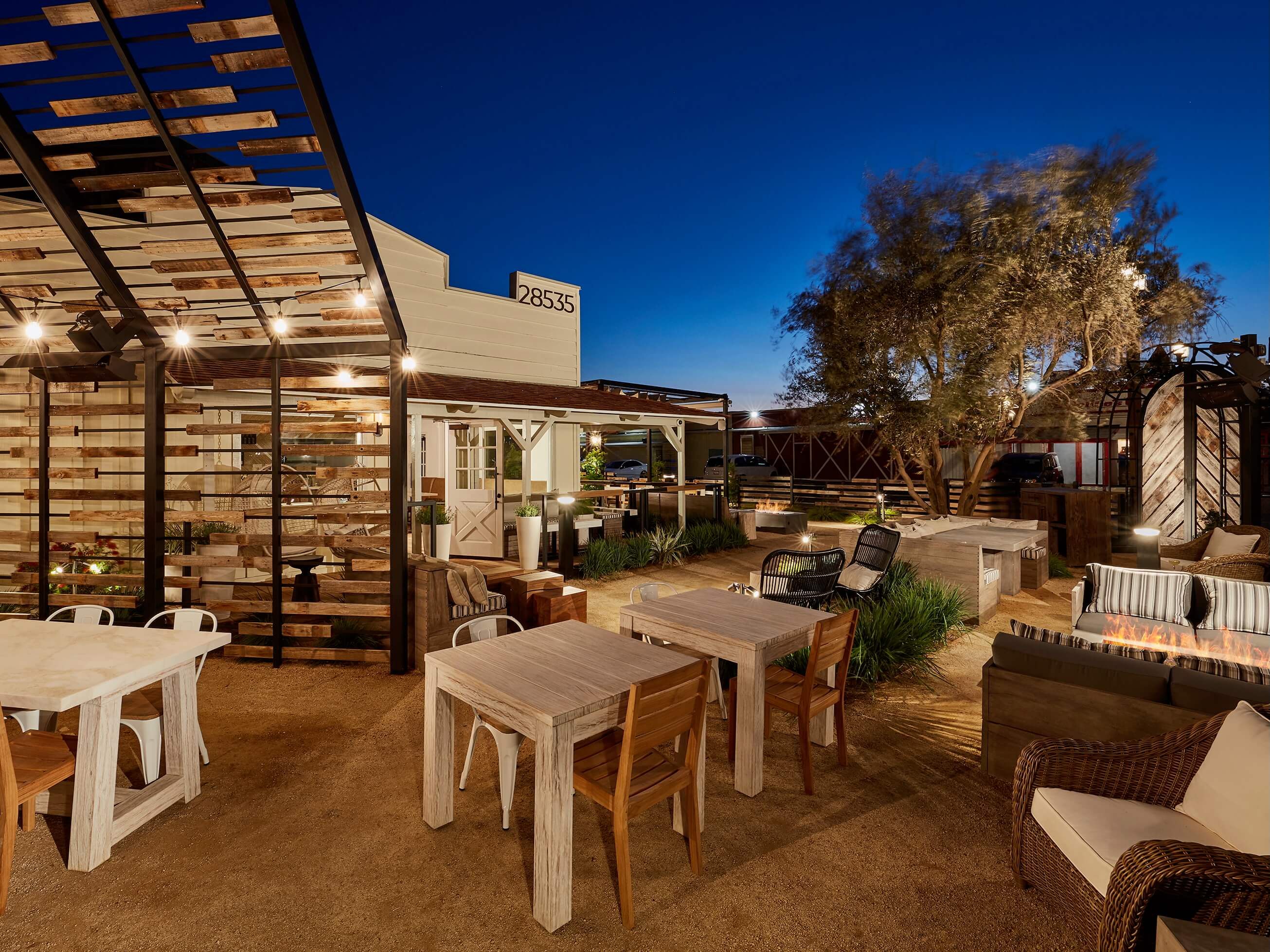 Outdoor dining tables and chairs on a dirt patio